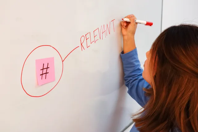 Woman writing the word 'RELEVANT' on a whiteboard with a red marker beside a sticky note hashtag. A six-block marketing automation strategy framework, from problem to measurement