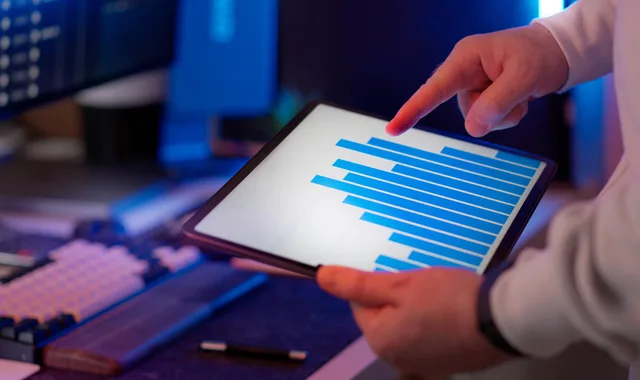 Business professional analyzing bar chart on tablet in office setting, highlighting data insights. Eight marketing automation strategy mistakes, beginning with calling activity an outcome