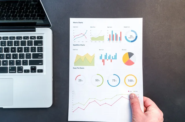 Detailed charts and graphs on a document next to a laptop, representing data analysis. The marketing automation outlook for England, with four labels that keep forecasts honest